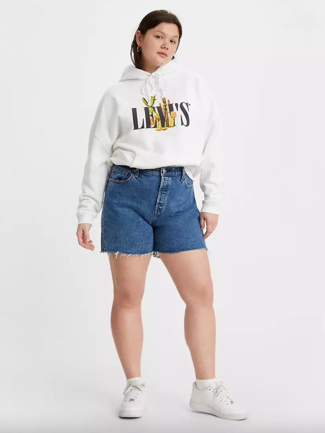 The 501 shorts on a model in a sweatshirt and sneakers