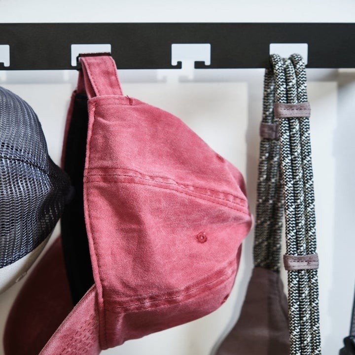 Over-the-door hat hanger with hats and a bag hanging from loops