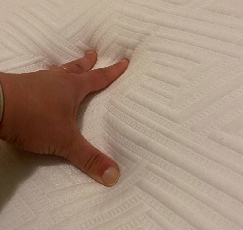 An Amazon reviewer touching the queen-sized mattress