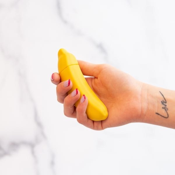 a model holding the banana vibrator in their hand 