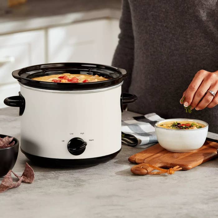 A model making dip using the off-white Crock Pot
