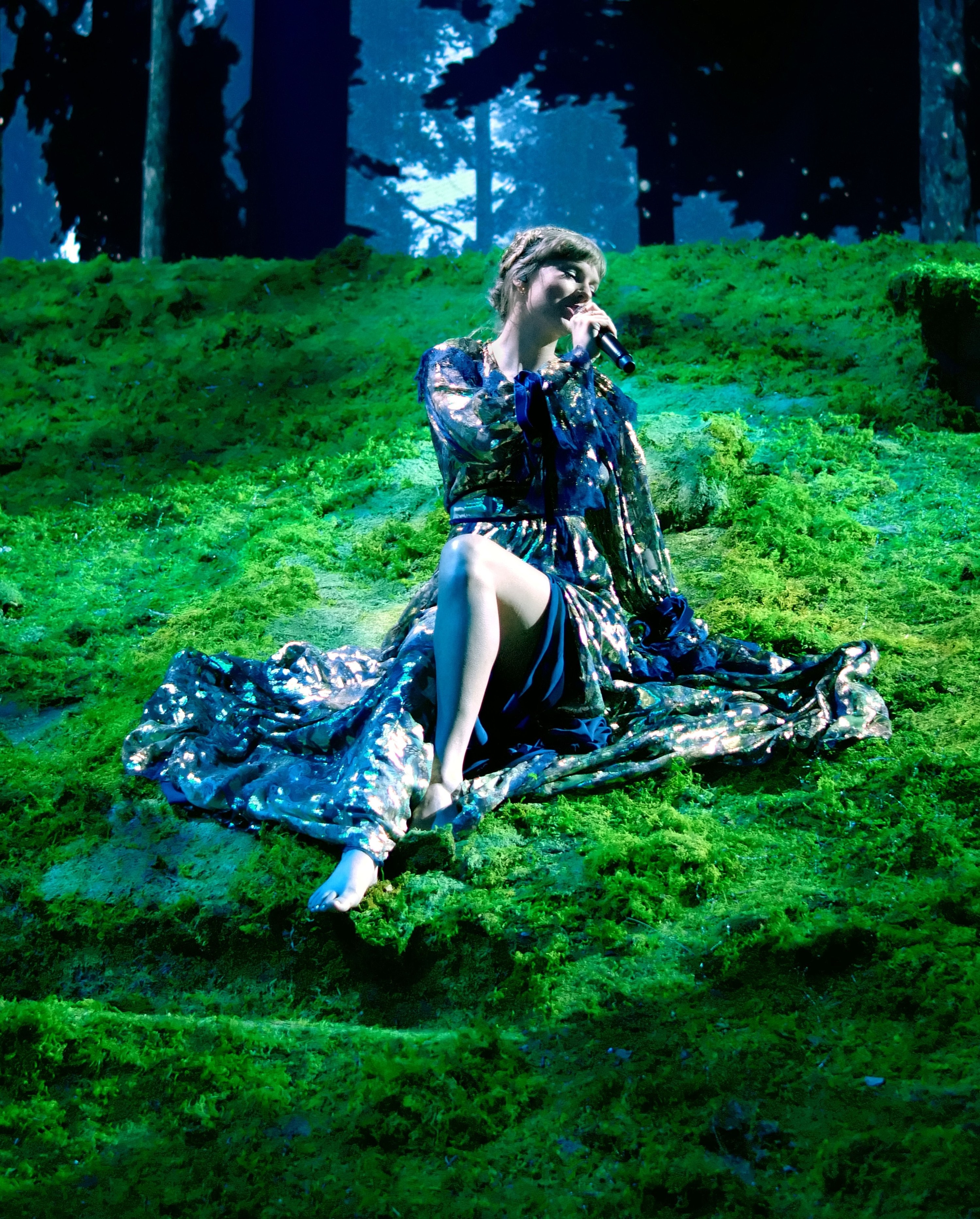 Taylor swift leans against the moss-covered roof