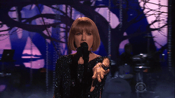 Taylor swift wears a black jumpsuit while performing at the 2016 Grammy Awards