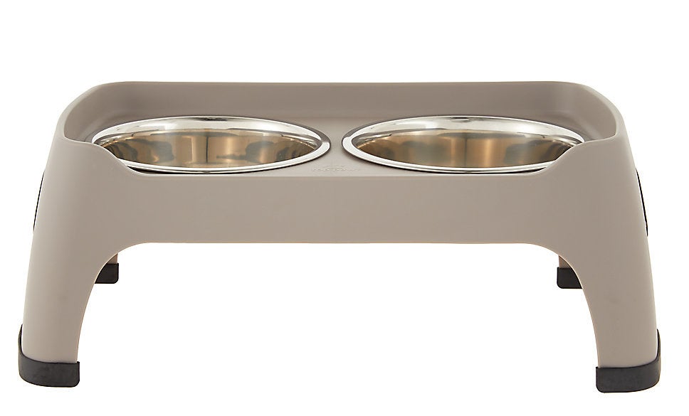 a tan elevated dog feeder with two bowls in it
