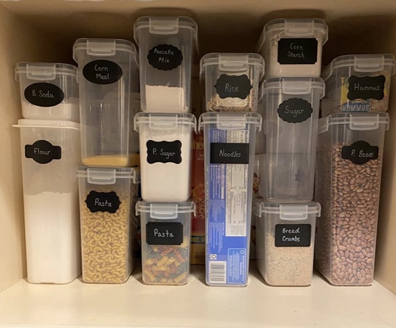 Stacked food storage containers filled with various food items in a reviewer&#x27;s pantry