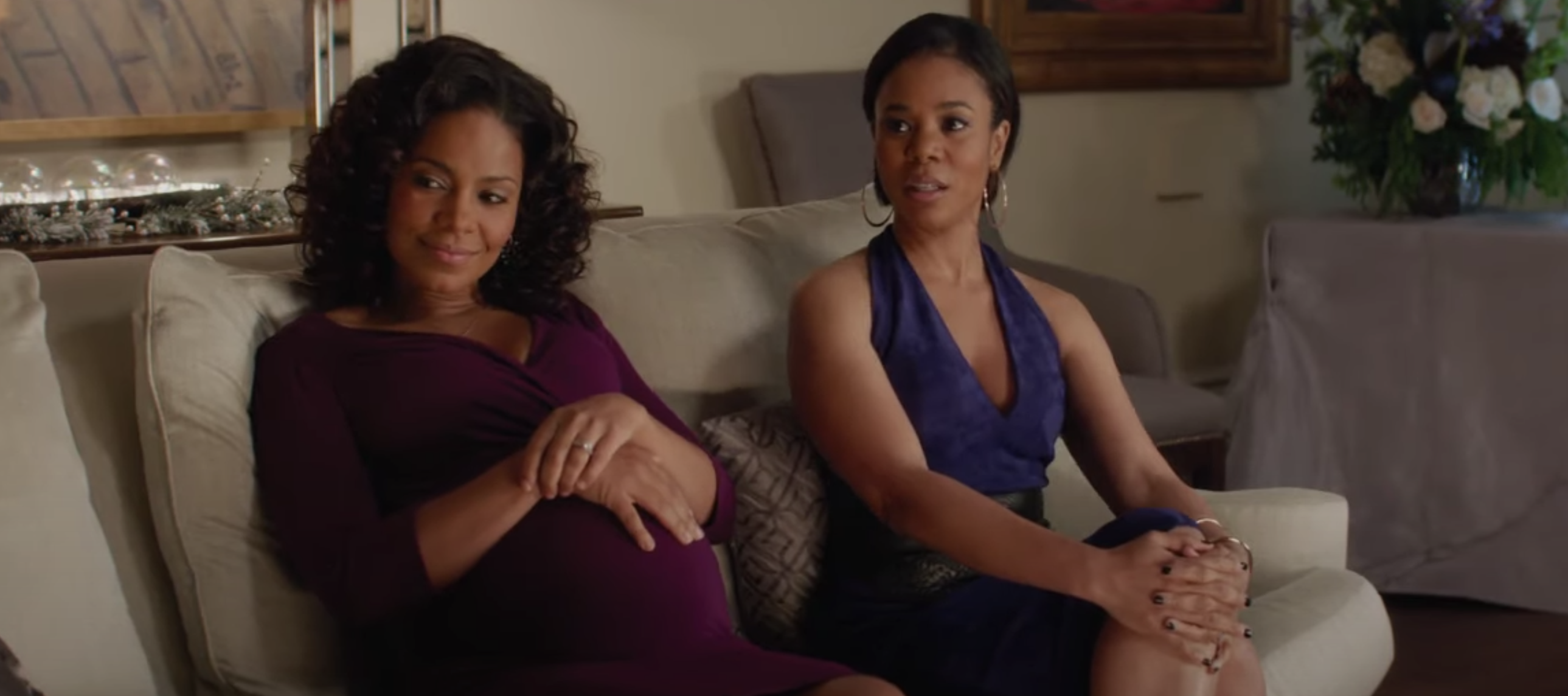 A pregnant woman sitting on a couch next to a woman who isn&#x27;t