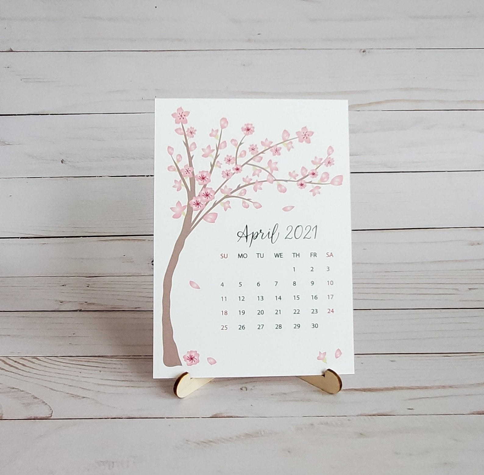 Mini desk calendar placed on stand with April 2021 page in the front