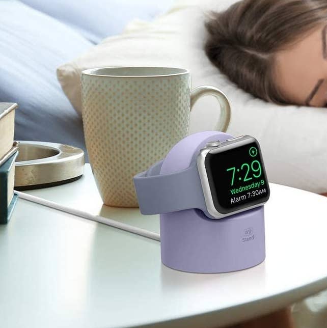 The stand on a bedside table with an apple watch on it