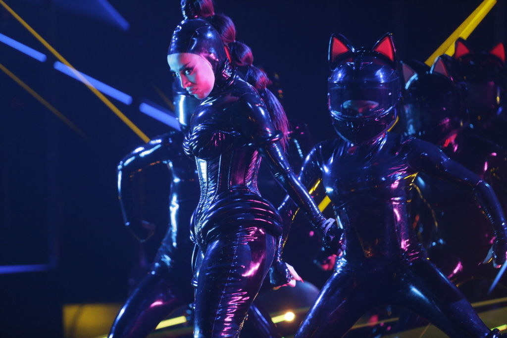 Doja Cat performing with her backup dancers in futuristic bodysuits