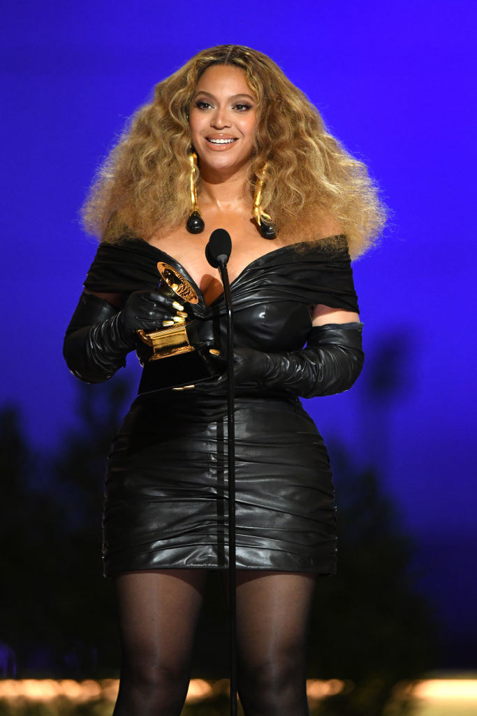 Beyonce in a short off-shoulder leather dress and tights