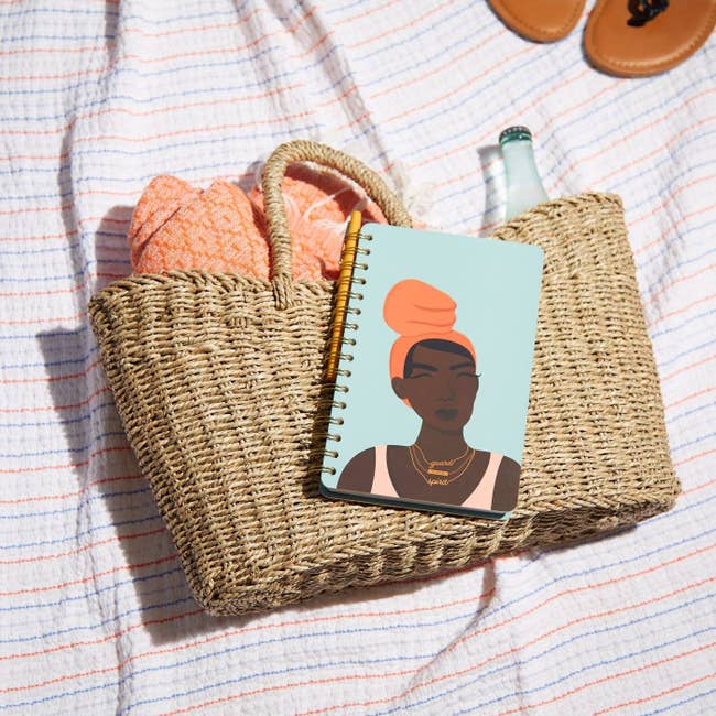 Light blue notebook with illustration of black woman wearing a necklace that says guard your spirit