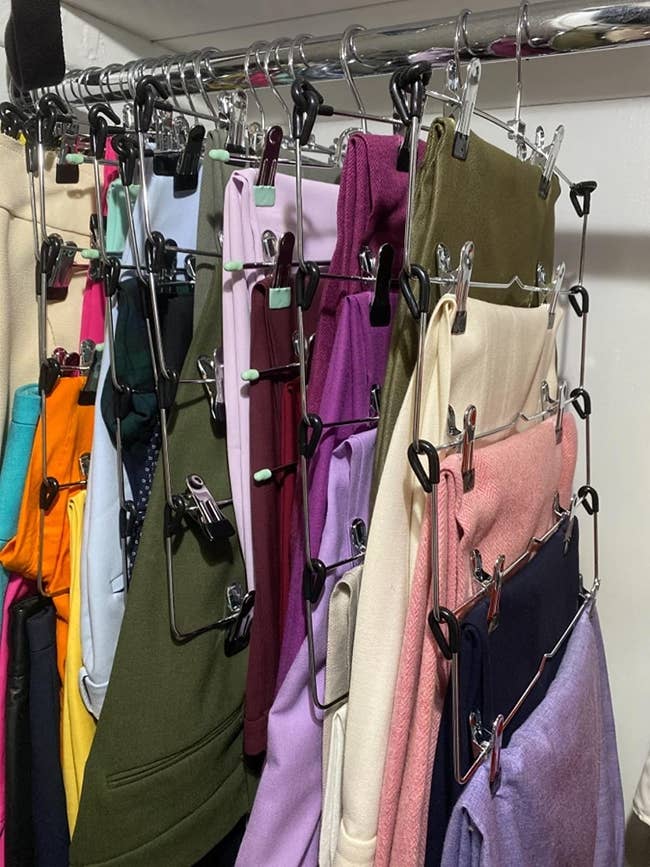 Reviewer photo of various clothing items hanging from skirt hanger