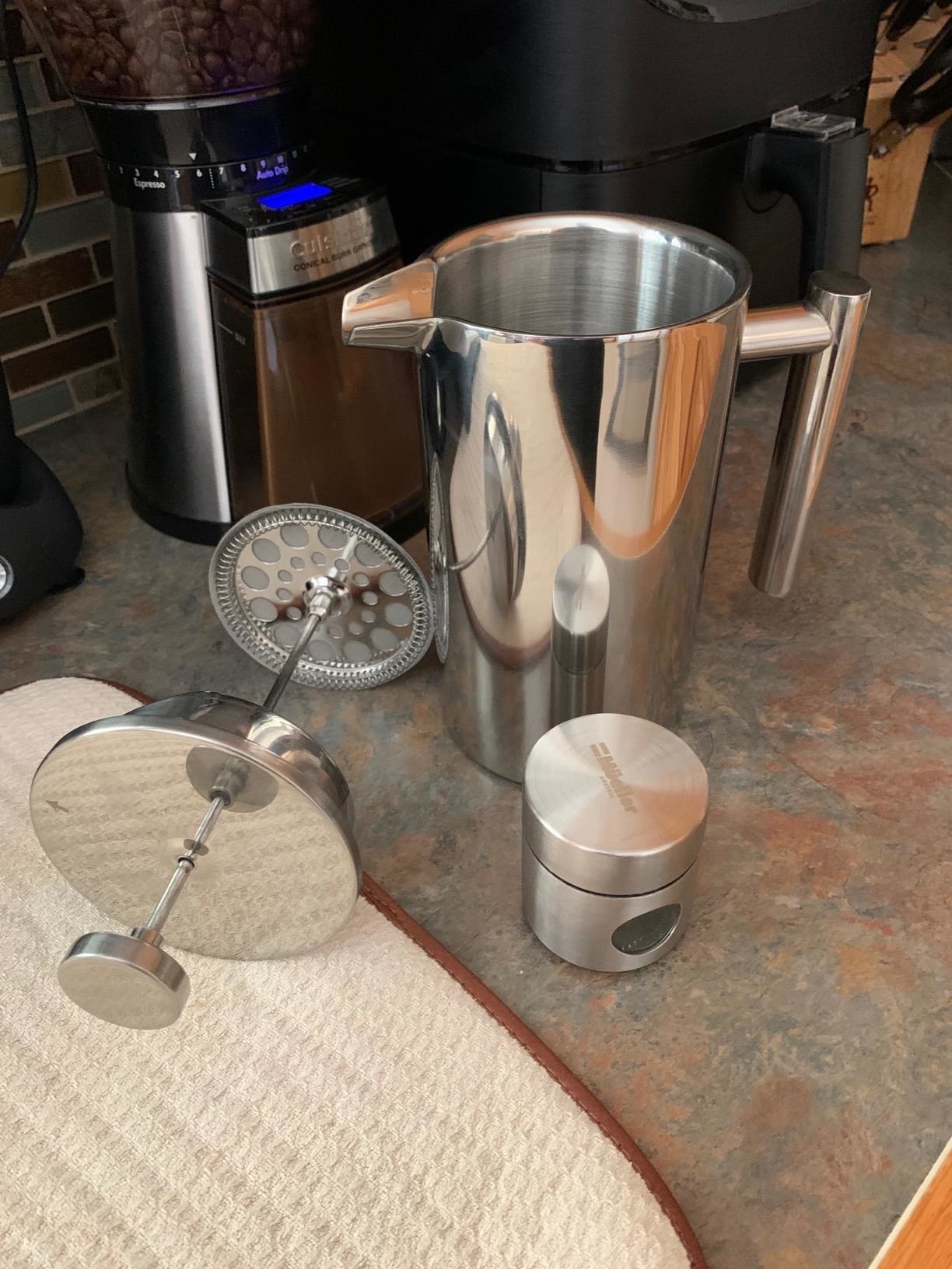 The silver-colored French Press with the stopper out.