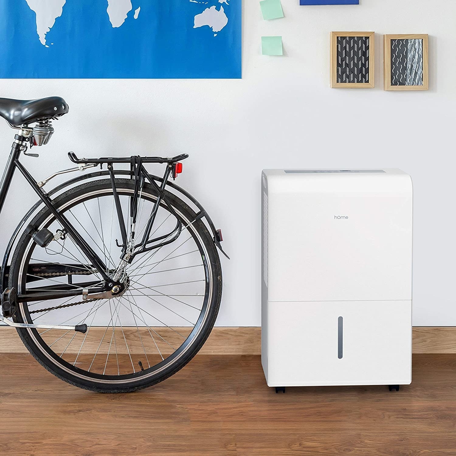 A white dehumidifier with a black bike, for scale