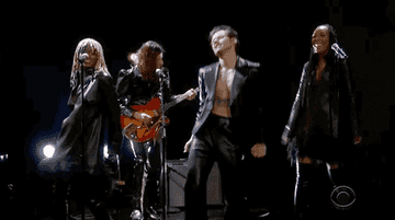 A GIF of Harry Styles dancing with his backing singers.