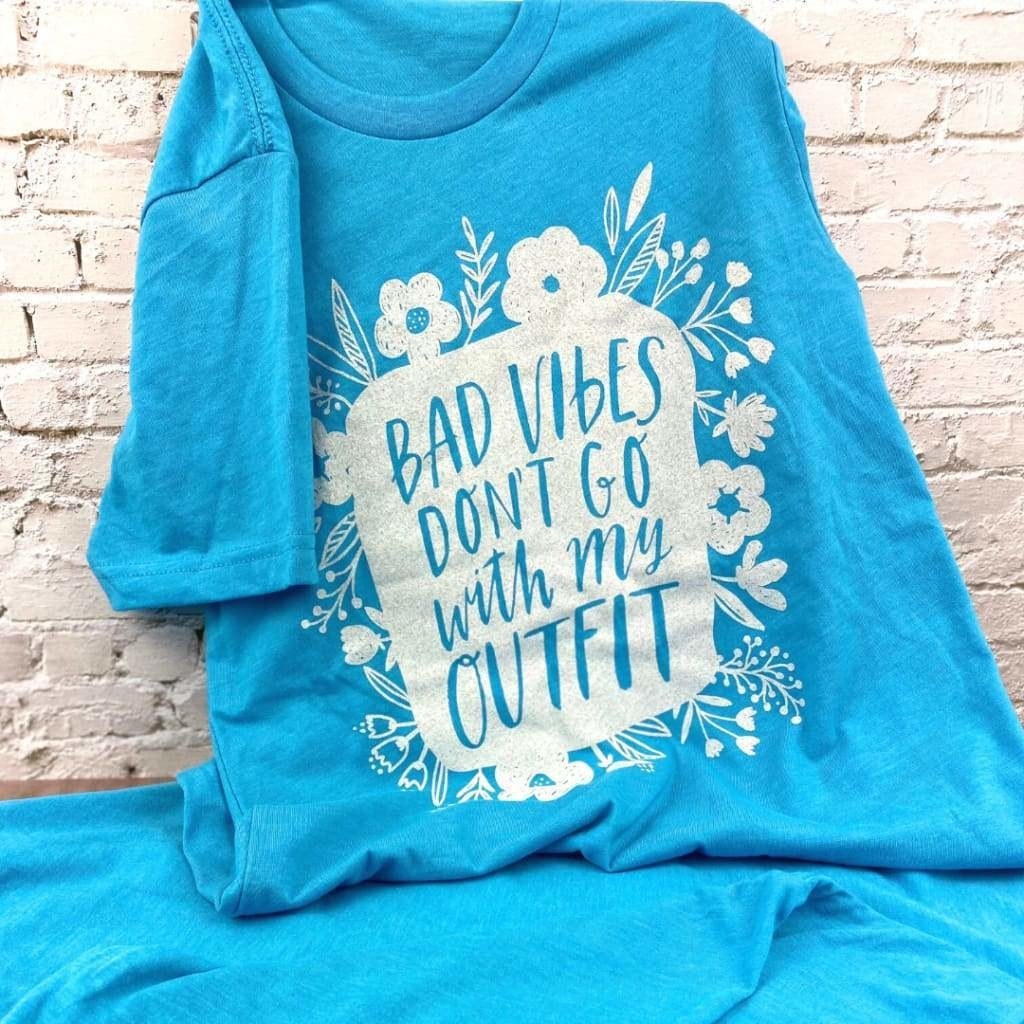 blue short sleeve tee printed with white flowers and the text &quot;Bad vibes don&#x27;t go with my outfit&quot;