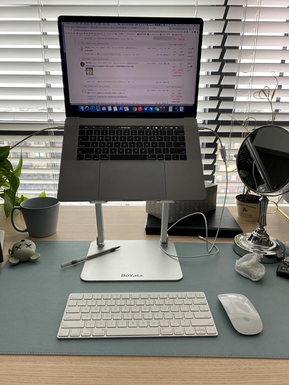 reviewer image of the white wireless keyboard in front of a laptop stand with a laptop on it