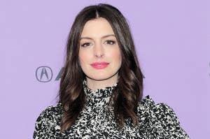 Anne softly smiles on a red carpet while wearing her hair down