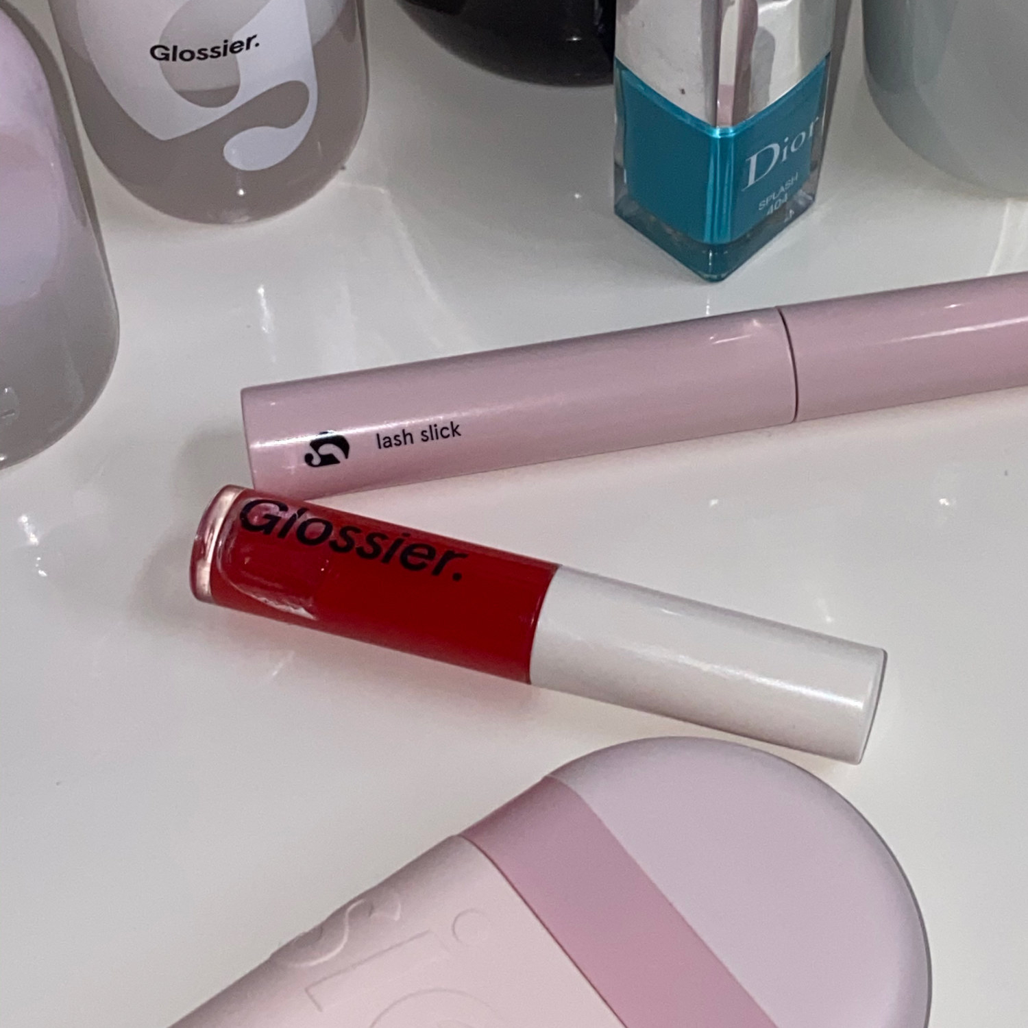 the mascara, a lip gloss, and a hand cream on a table
