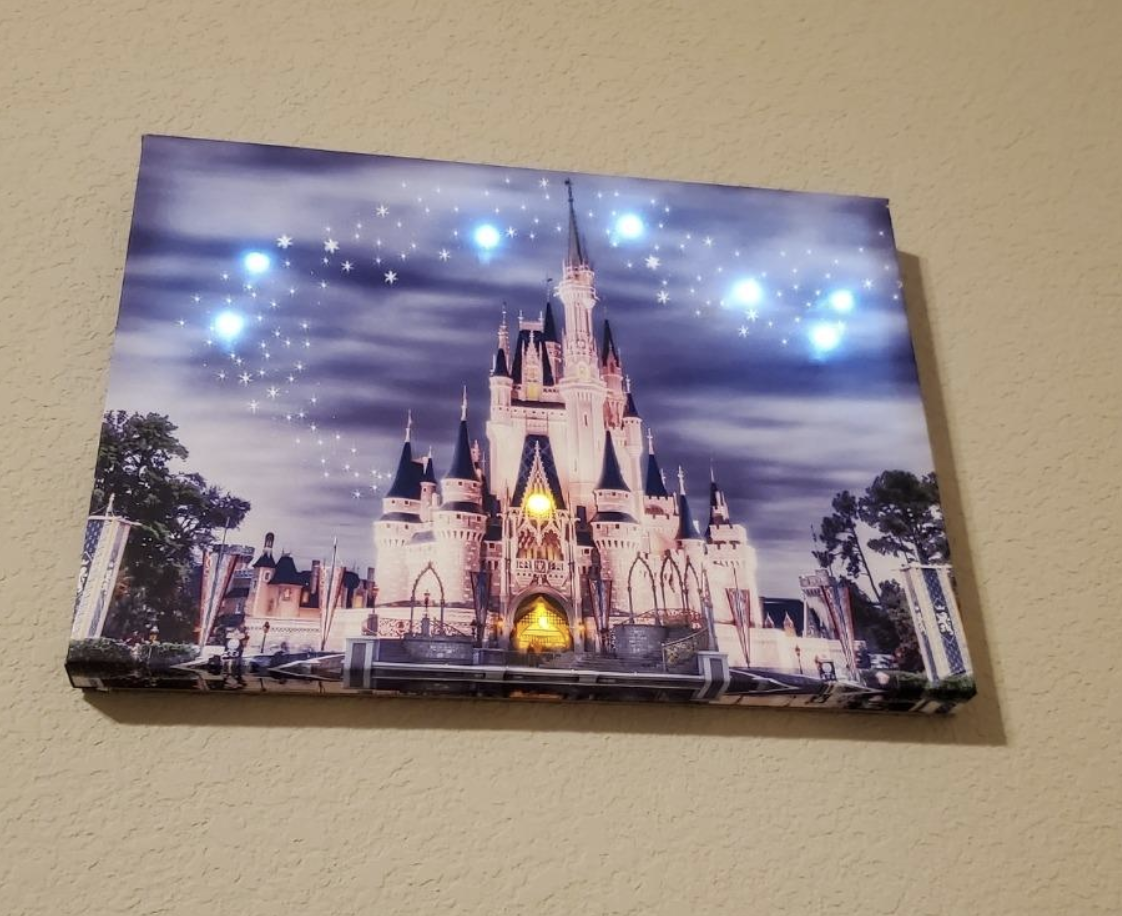 Canvas image of Disney castle with lights at the entrance and in the sky 