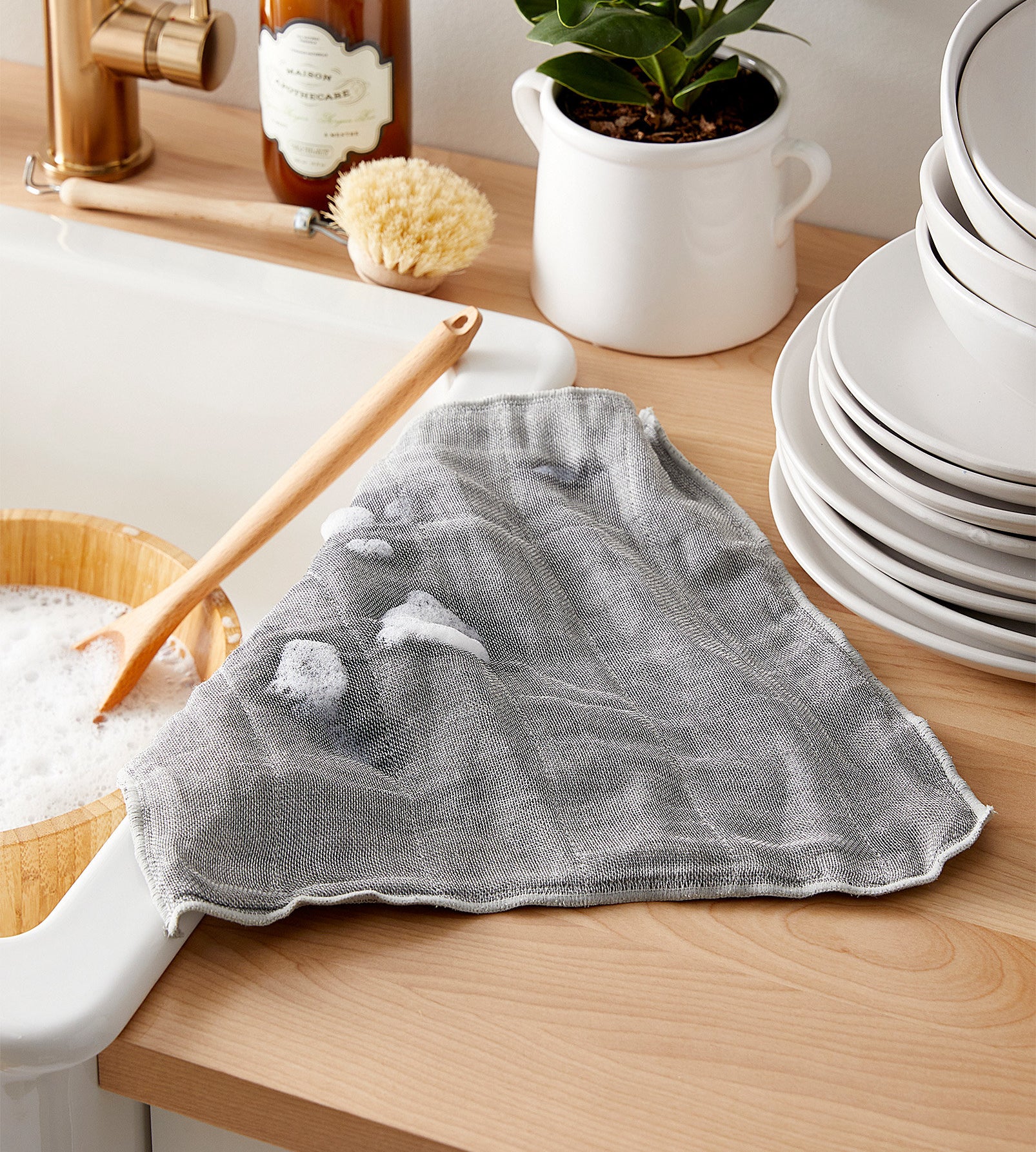 The bamboo-infused cloth next to a soapy dish sink