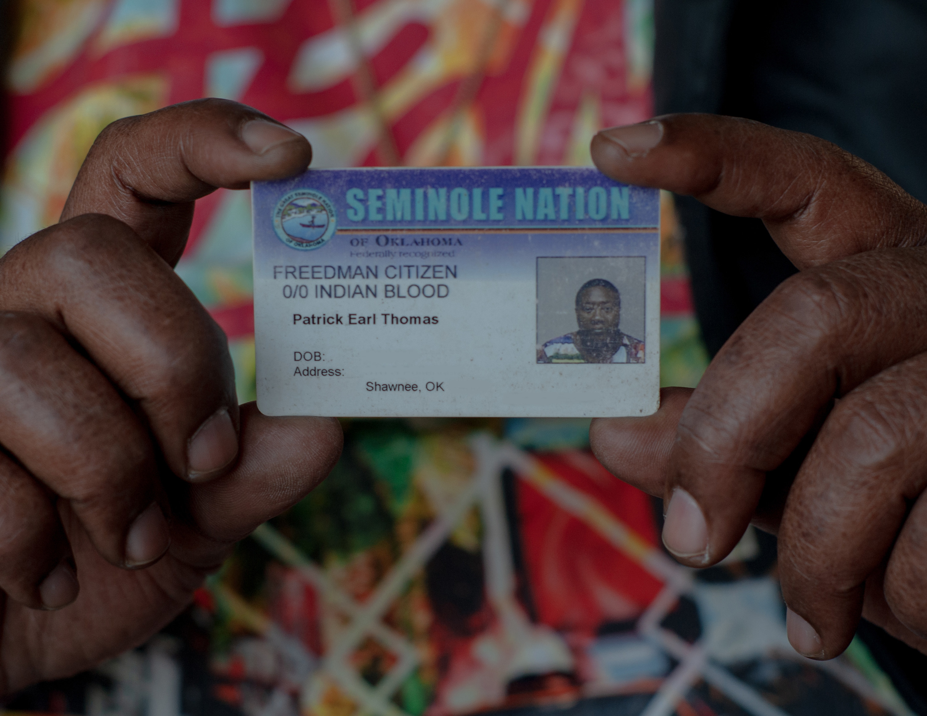 Patrick Earl Thomas holds up his ID card, which says &quot;Freedman Citizen, 0/0 Indian Blood&quot;