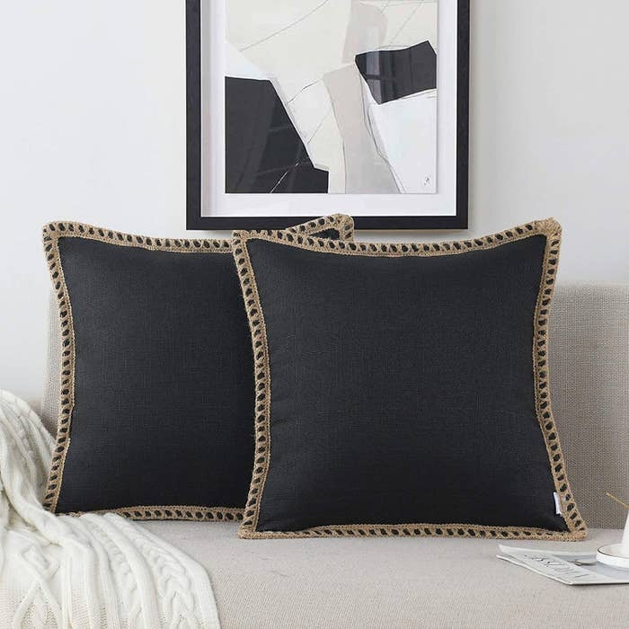 Two square pillows in soft black color with burlap sewn edges 