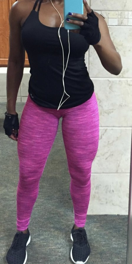 A woman standing in hot pink leggings