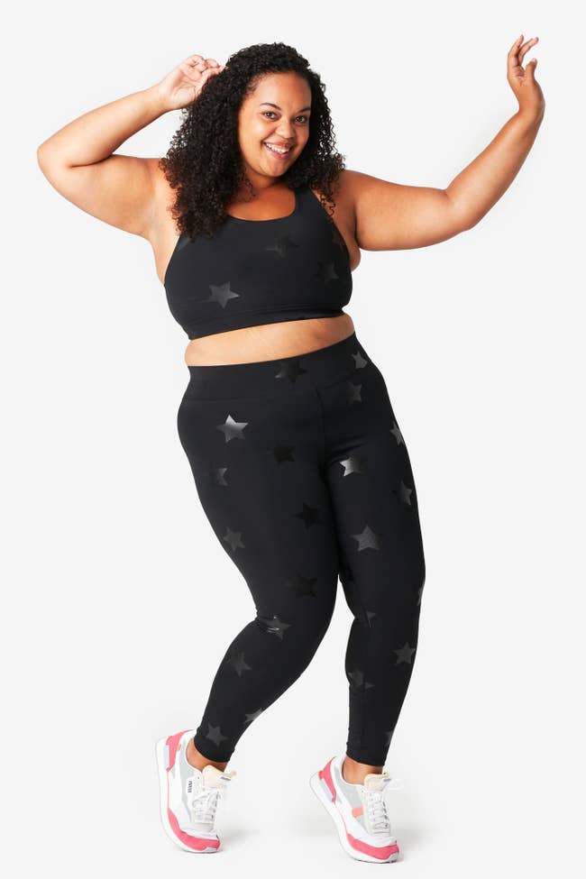 a model in black leggings with black foil stars on them
