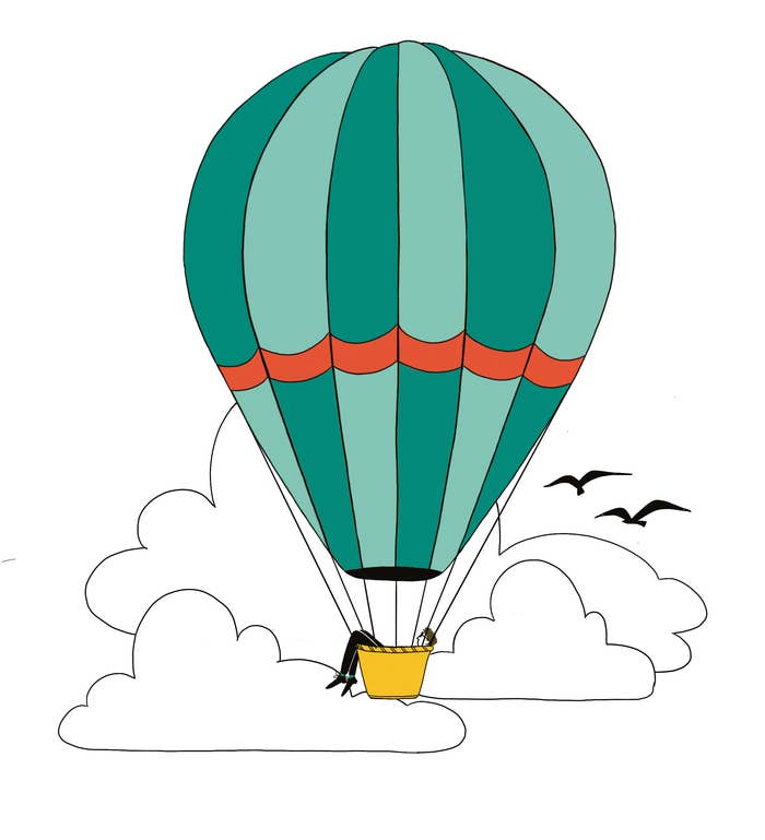 A person floats in a cloudy sky in a hot air balloon, with legs dangling over the side of the basket. Two birds fly next to the balloon.