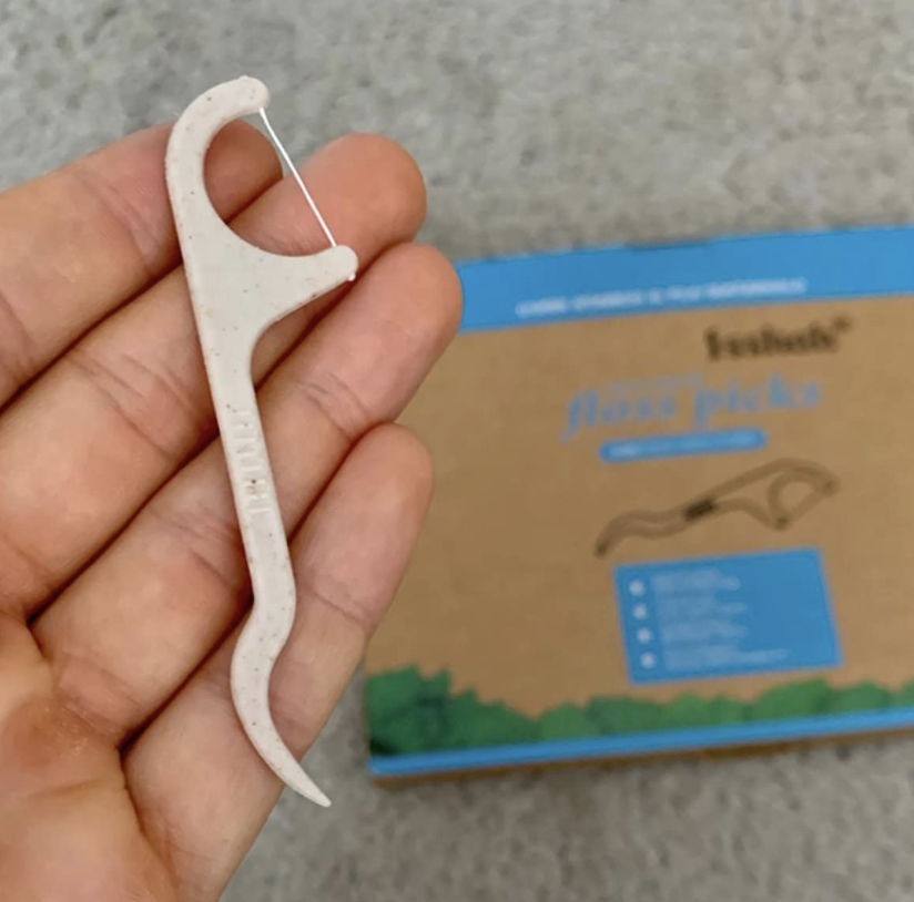 A reviewer holding the floss pick