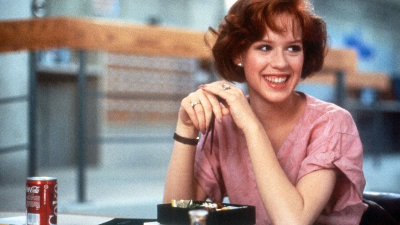 Molly Ringwald&#x27;s character smiling while eating food