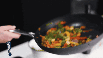 Stir-fry being swirled and cooked in a hot pan