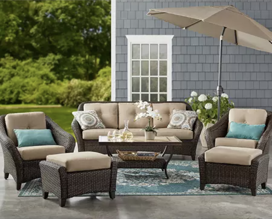 An outdoor patio set shaded by an umbrella.