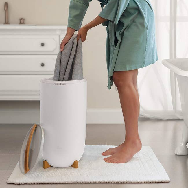 A model taking a towel out of the white warmer