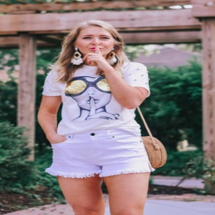 person wearing a pair of white jean shorts