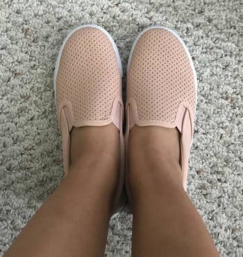 a reviewer photo of someone wearing the slip-on sneakers in pink 
