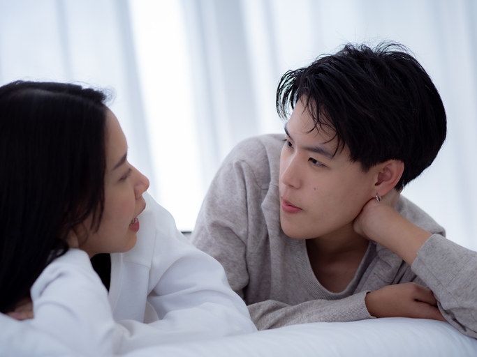 Couple talking earnestly in bed