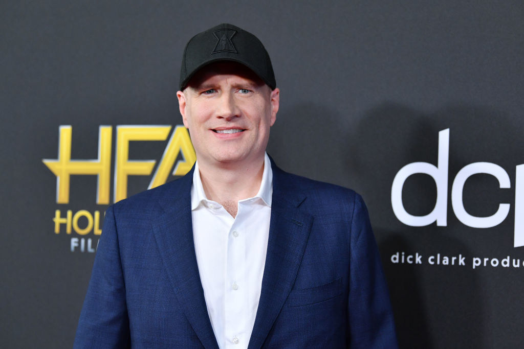 Kevin Feige in his signature baseball cap posing on a red carpet