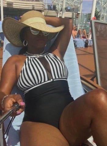 person wearing a one-piece swimsuit with stripes on the top and black on the bottom