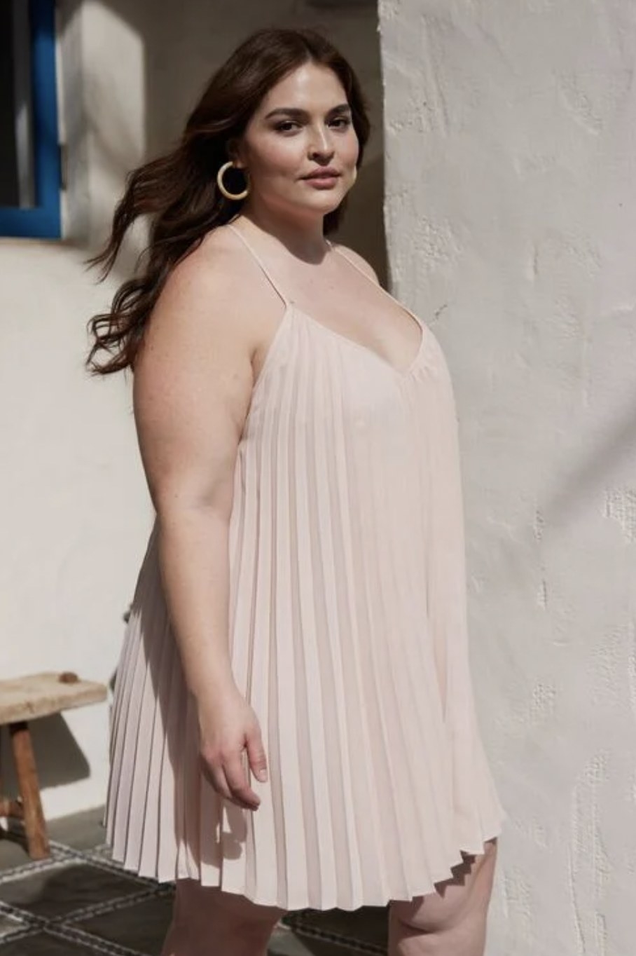 model in a cream pleated above the knee dress