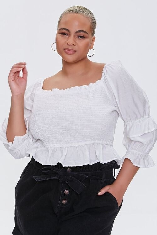 model wearing a white blouse with ruffle sleeves and hem