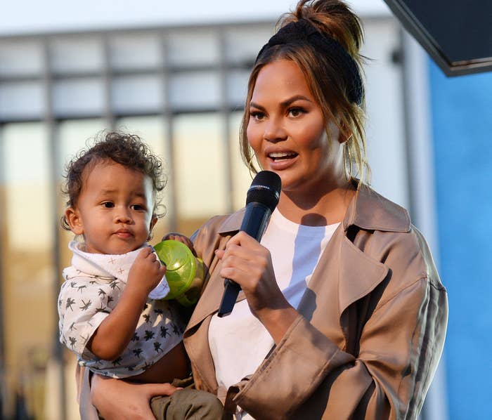 Chrissy holds her son Miles at an event