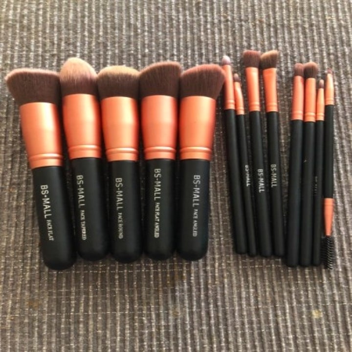 a set of makeup brushes laid out on a rug
