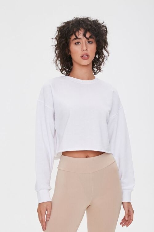 model wearing a cropped white pullover 