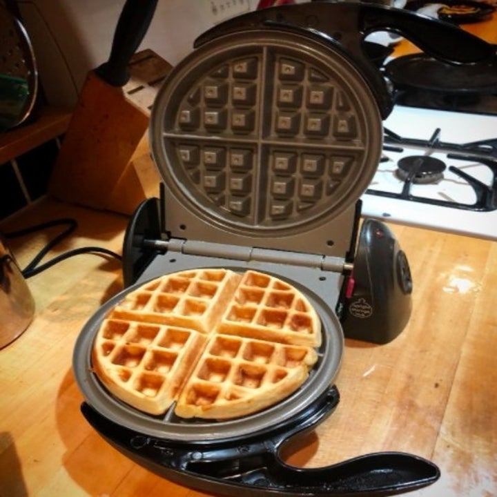 an open waffle maker with a cooked waffle inside of it
