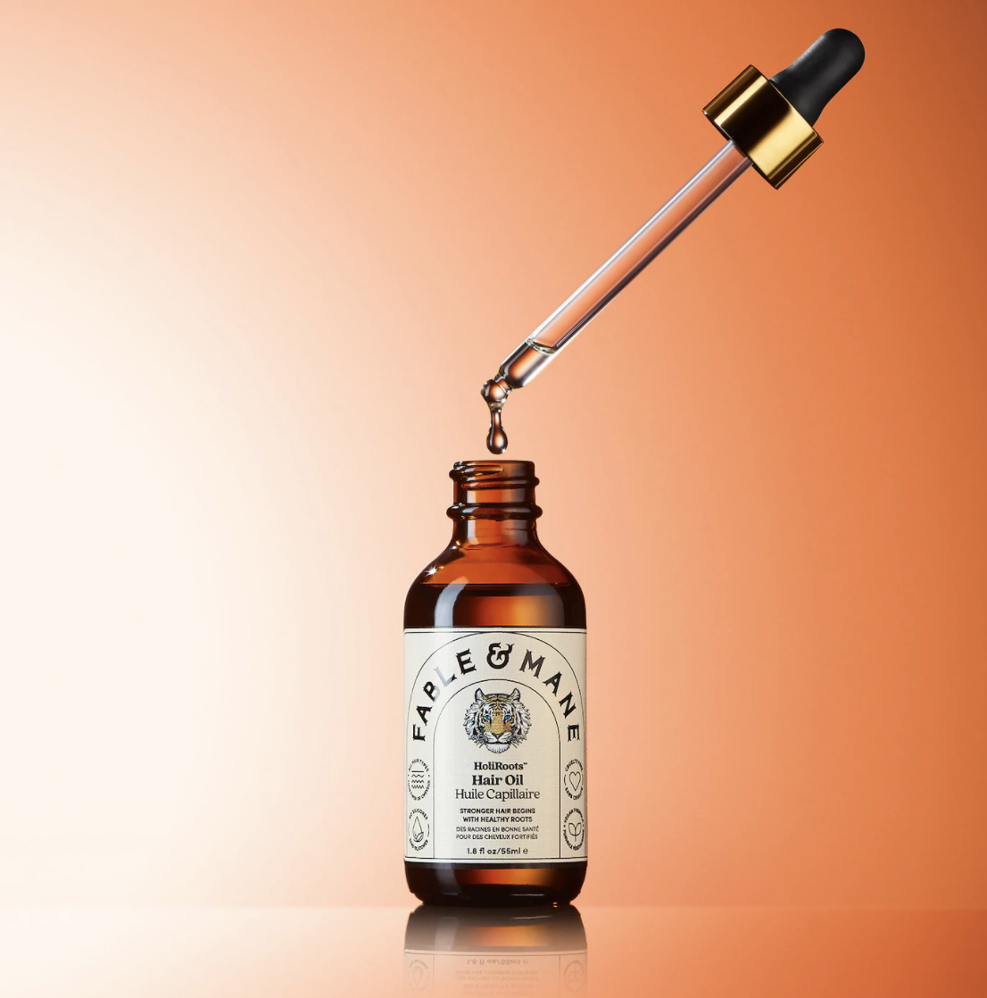 the bottle of the hair oil with a dropper on top