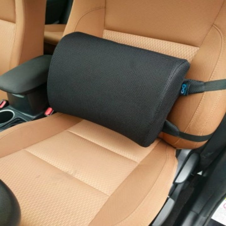 a black memory foam back pillow attached to a car seat