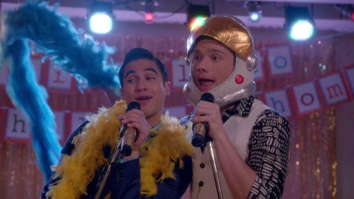 Kurt and blaine singing karaoke in feather boas and astronaut helmets