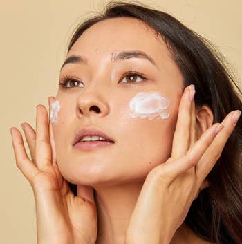 a model using foamy facial cleanser on their face